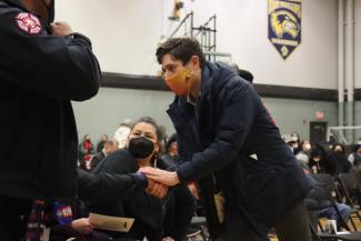 Men in Masks shaking hands at a funeral 